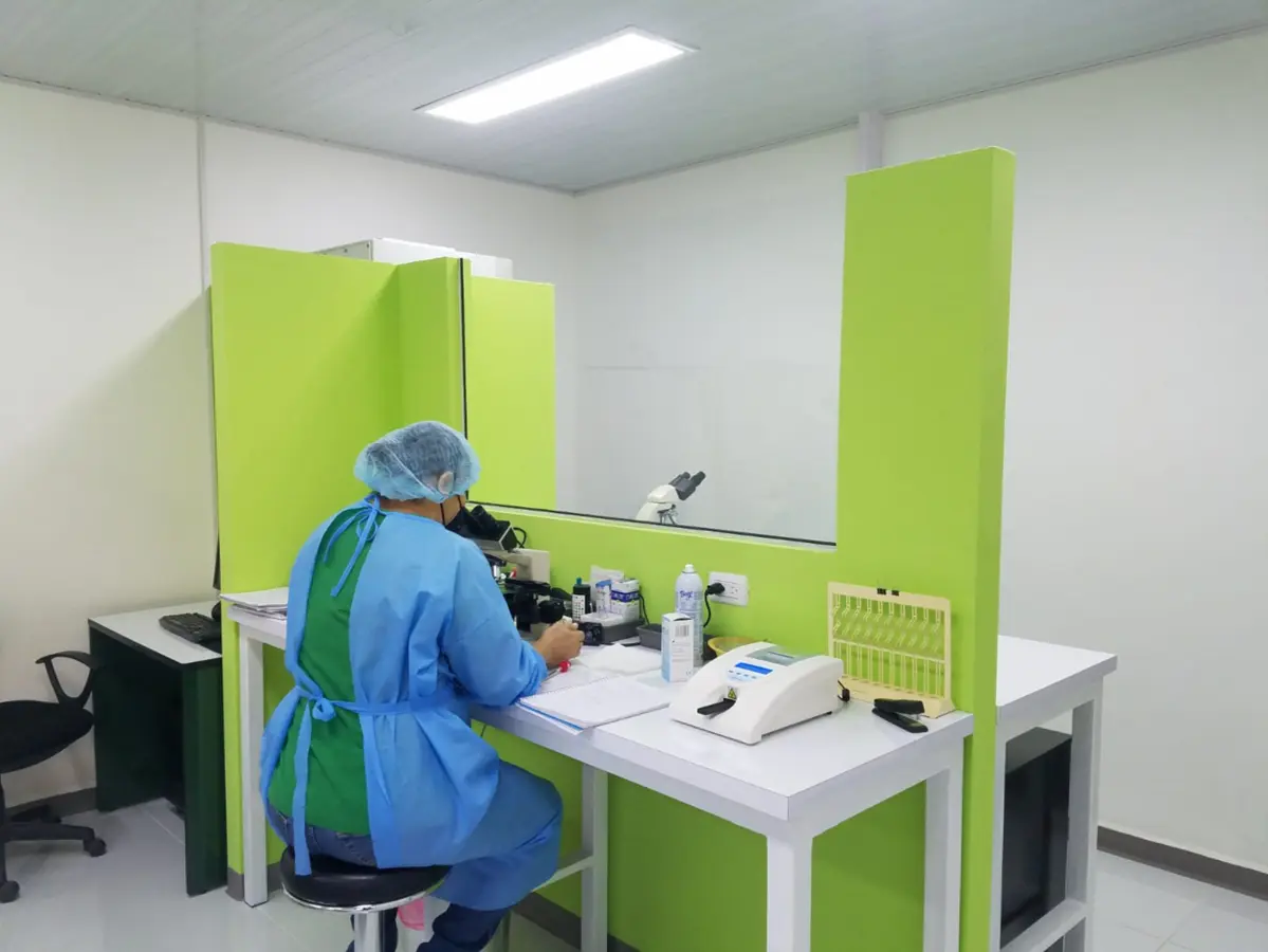 Profesional de Laboratorios Fleming realizando un análisis con microscopio